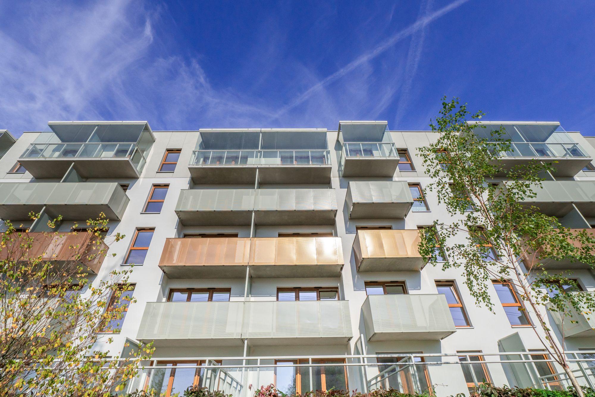 3 Paleta naturalnych kolorów ziemi —szarość, złamana biel, zieleń oraz akcenty miedziane i drewniane — łagodzi miejski krajobraz.jpg
